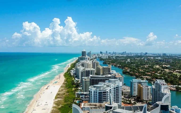 South Beach in Miami. Full view of the beach on the left and the city on the right. Beautiful blue sky on a clear day.