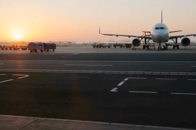 The plane in front of the airport terminal at sunrise