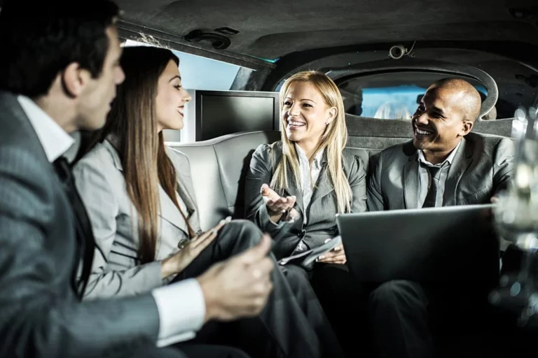 Four professionals sitting inside an executive limo.