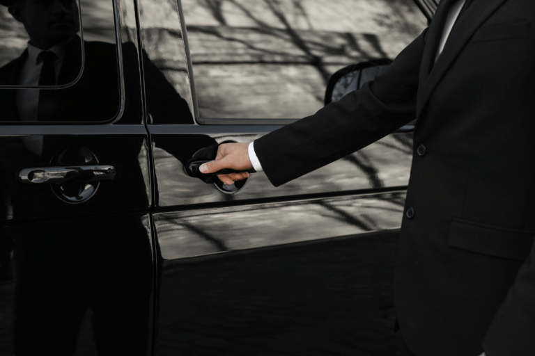A driver opening a door in a private car service