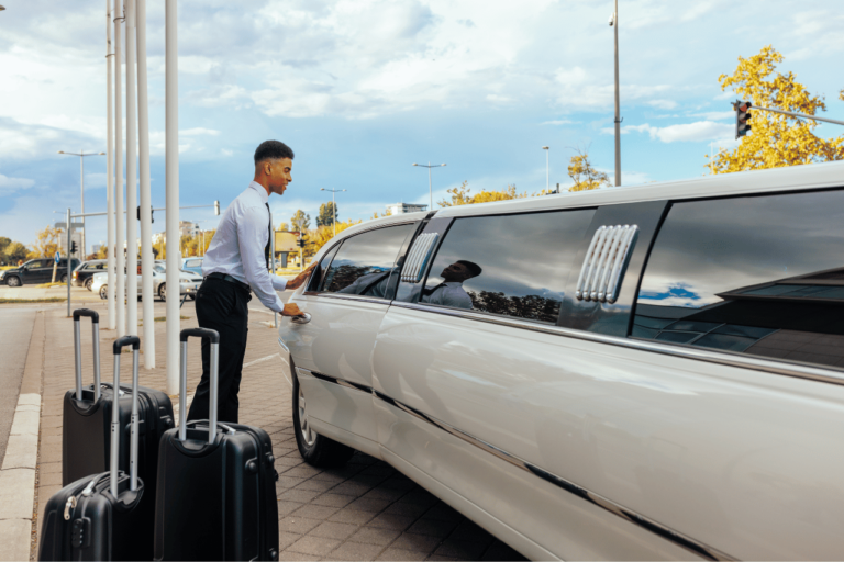 A limo driver showing that luggage can fit in the limousine trunk