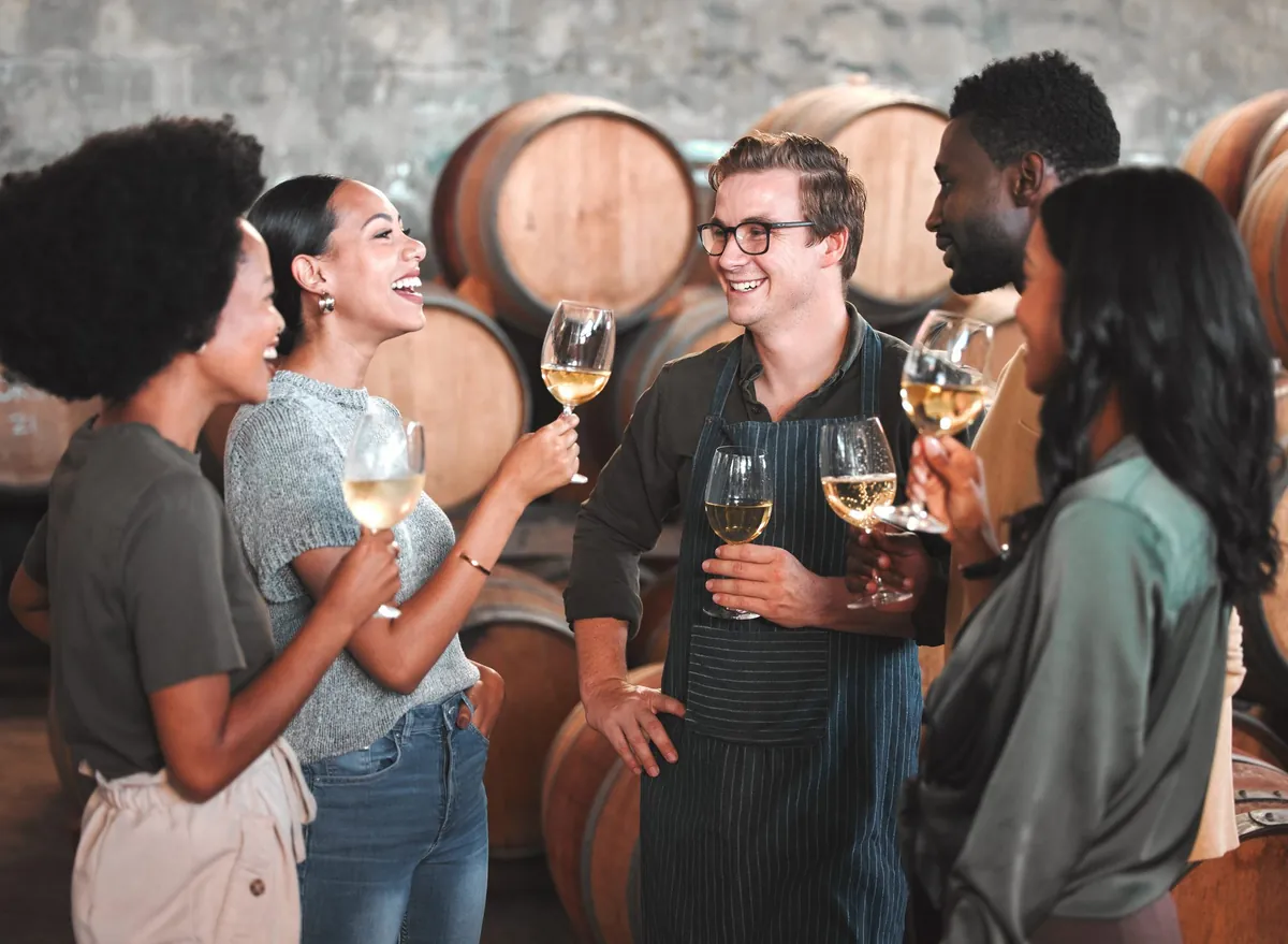 Friends tasting white wine in a winery barrel cellar